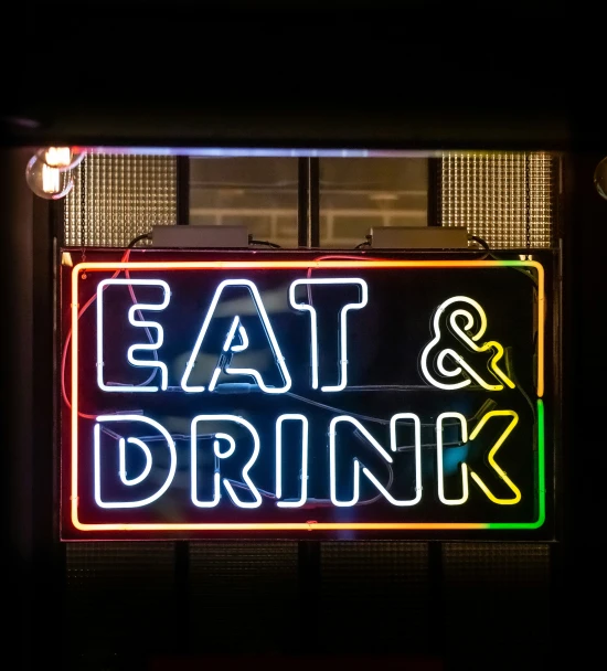 an illuminated sign that says eat and drink on it