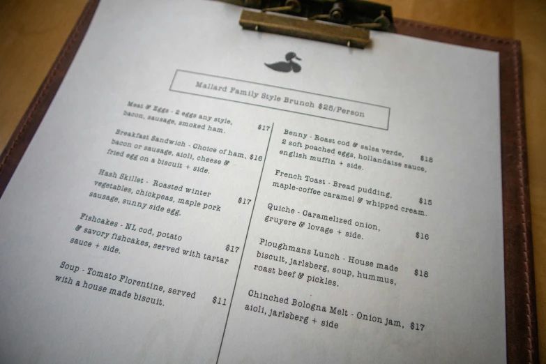 a menu with a brown clipboard and some writing on it