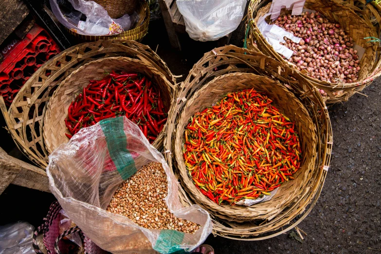 baskets filled with various colorful spices on top of a cement floor