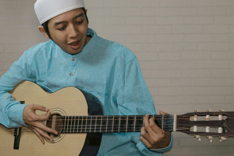 an indian man playing a guitar while wearing a white headdress