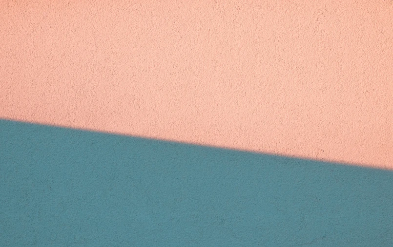 an orange and pink wall with blue ground