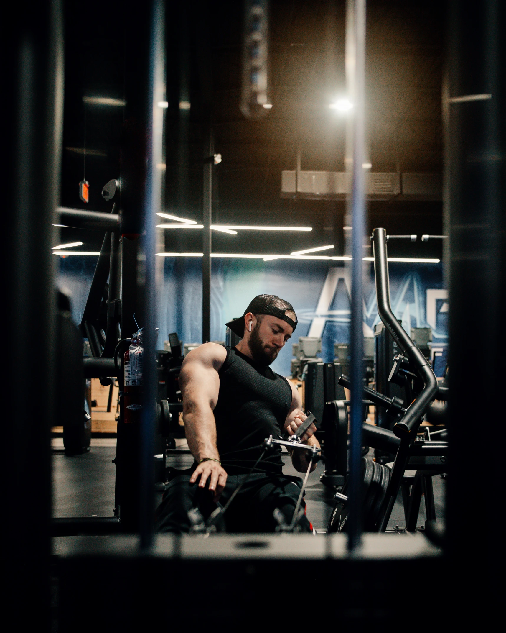 a man holding a bicycle while seated in a gym