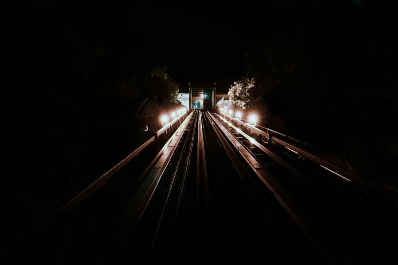 an electric train pulls into the dark with lights on