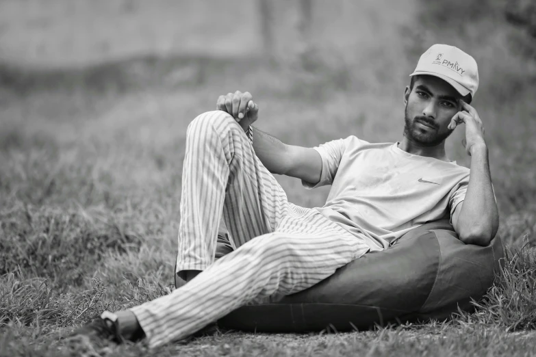 a baseball player is sitting on the grass while talking on his phone