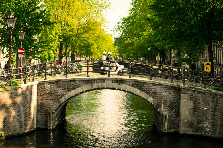 people walk over the bridge with bicycles on it