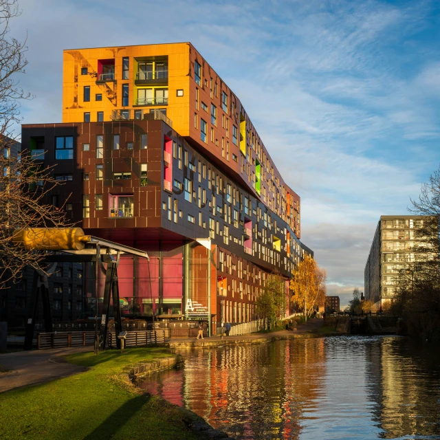 a colorful building on the edge of water near a city park