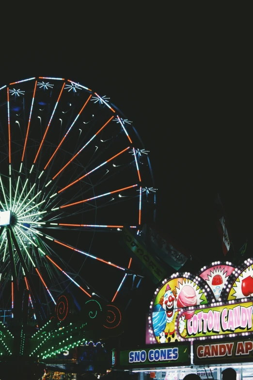 a carnival ride sits illuminated at night with lights