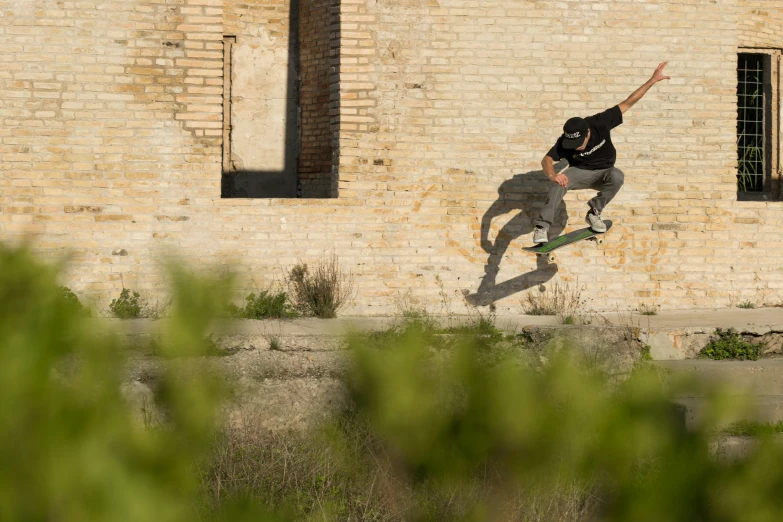 a person is skateboarding against a brick wall