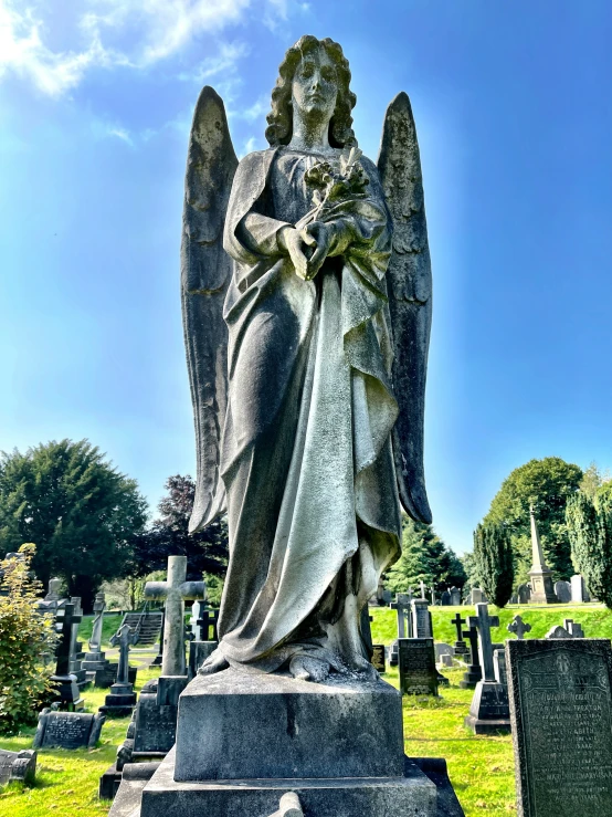 a graveyard with an angel sitting on top of it