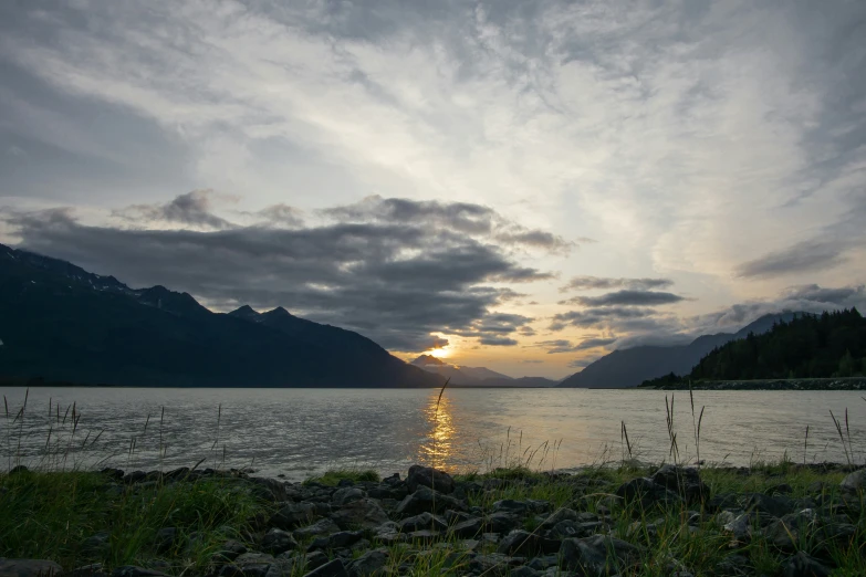 the sun is going down over a lake