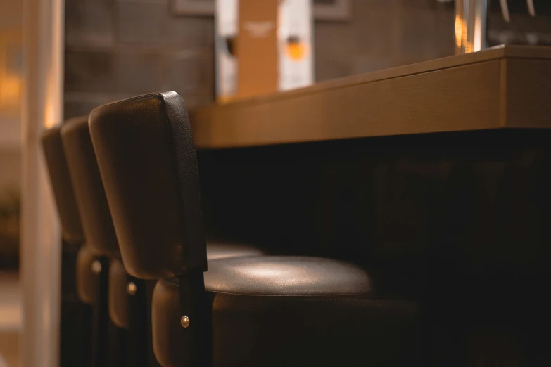 the back of a bar with leather stools