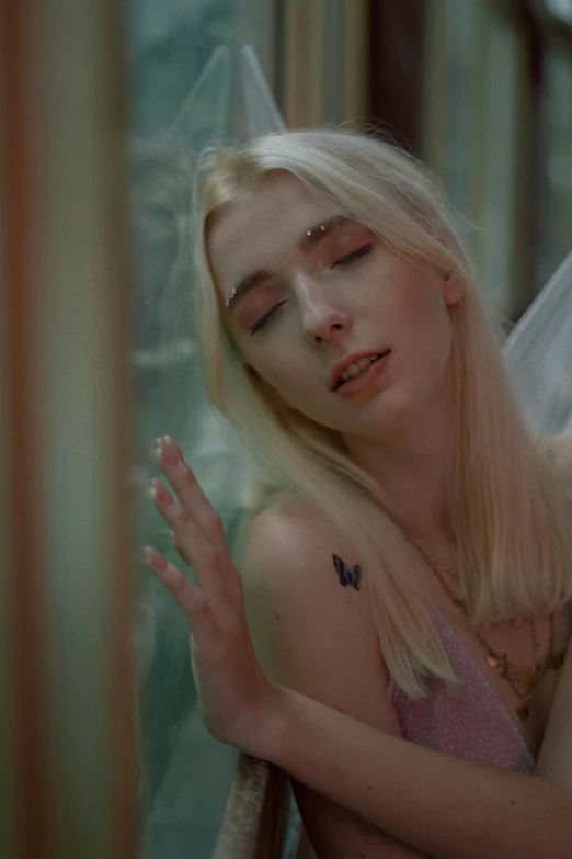 a blonde haired woman sleeping with a tattoo on her chest