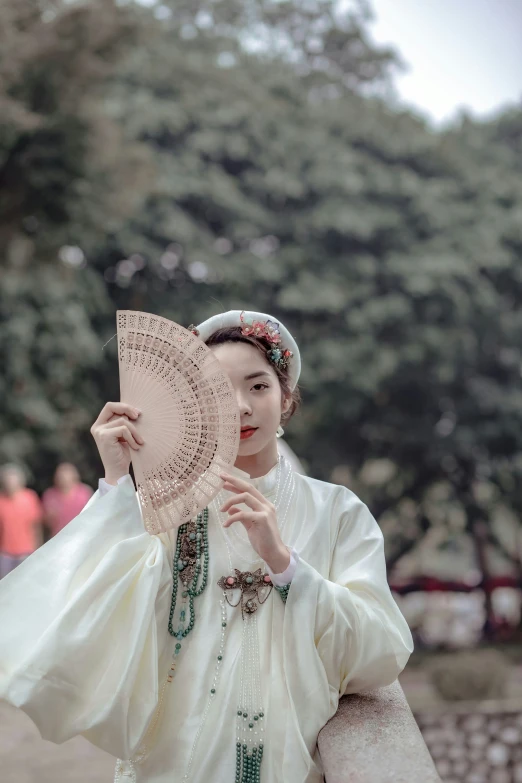 woman in a chinese costume holding up an ornate doily