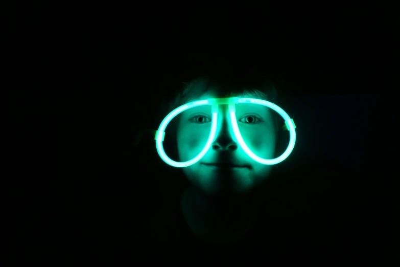 man with glasses and neon light in dark room