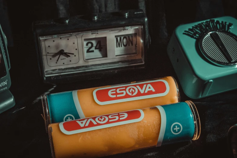 two batteries that are on a table near a clock