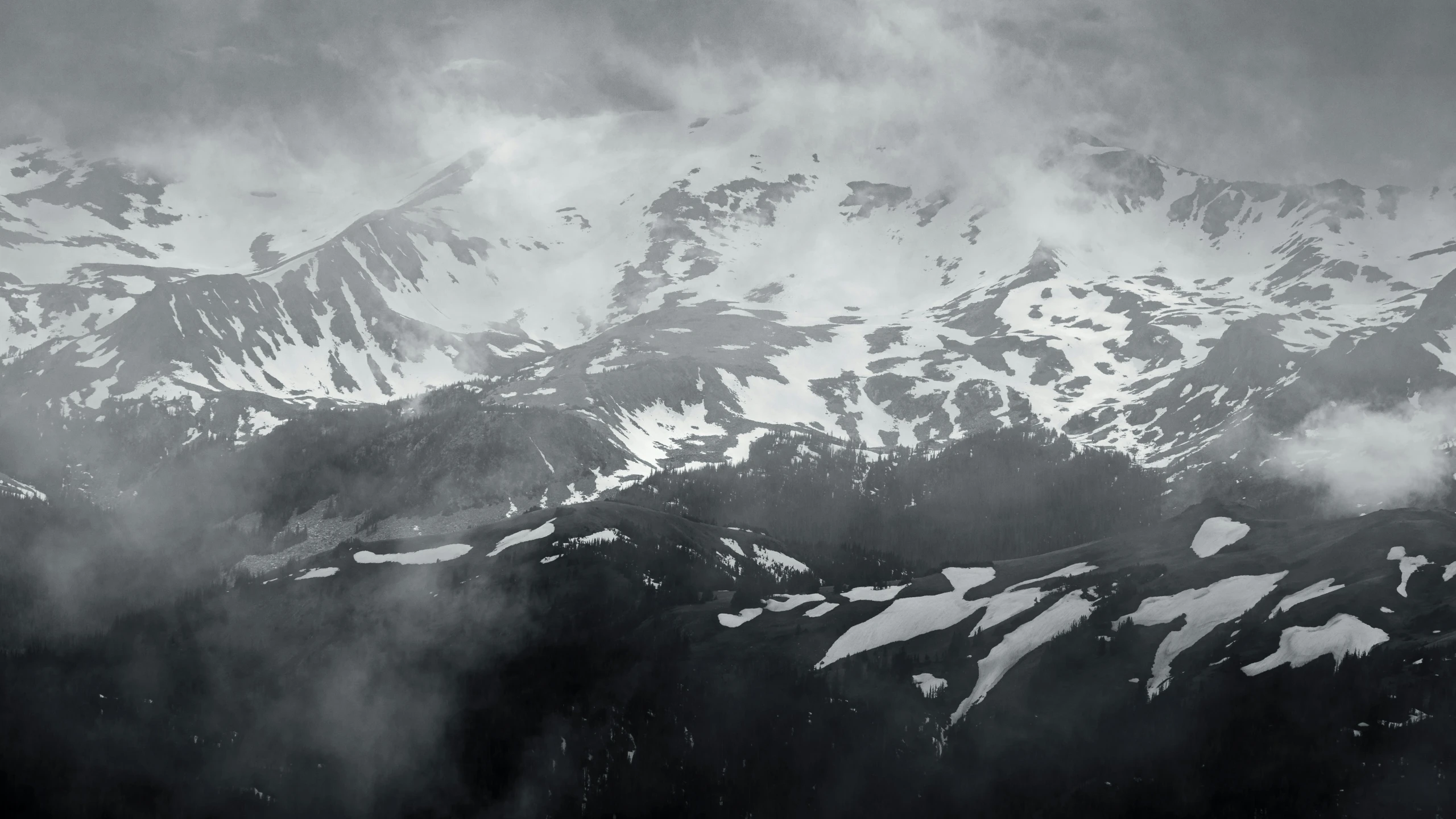 dark and cloudy view of mountains with snow