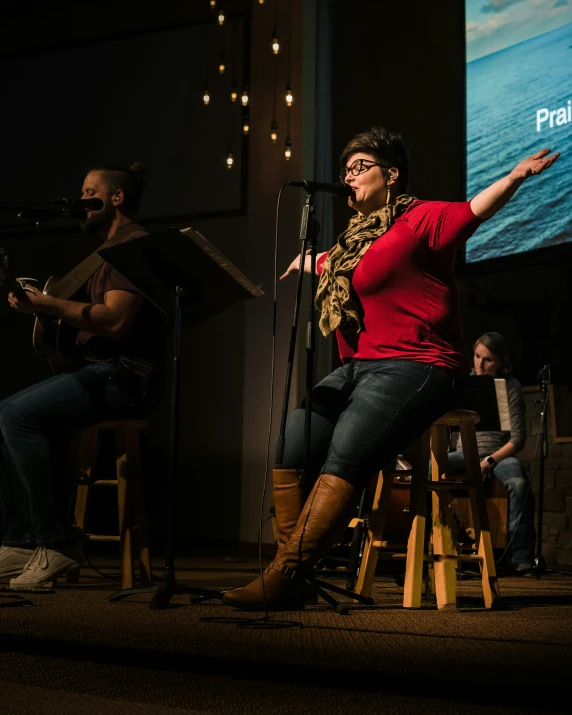 a woman is singing with an instrument on the stage