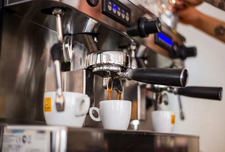 espresso machine with cups sitting in front of the espresso machine