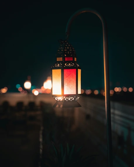 a large square colored lantern hanging in the dark