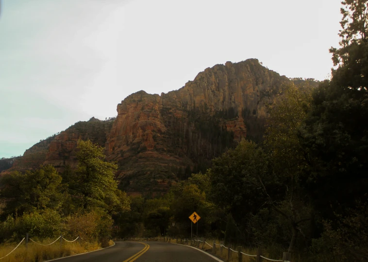 a scenic mountain range on a highway with a street sign