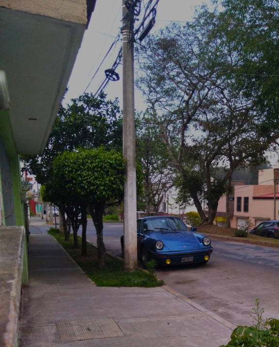 an old blue car parked on a street side