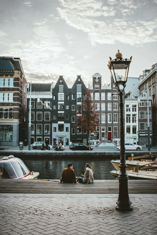 the people are sitting near a large waterway