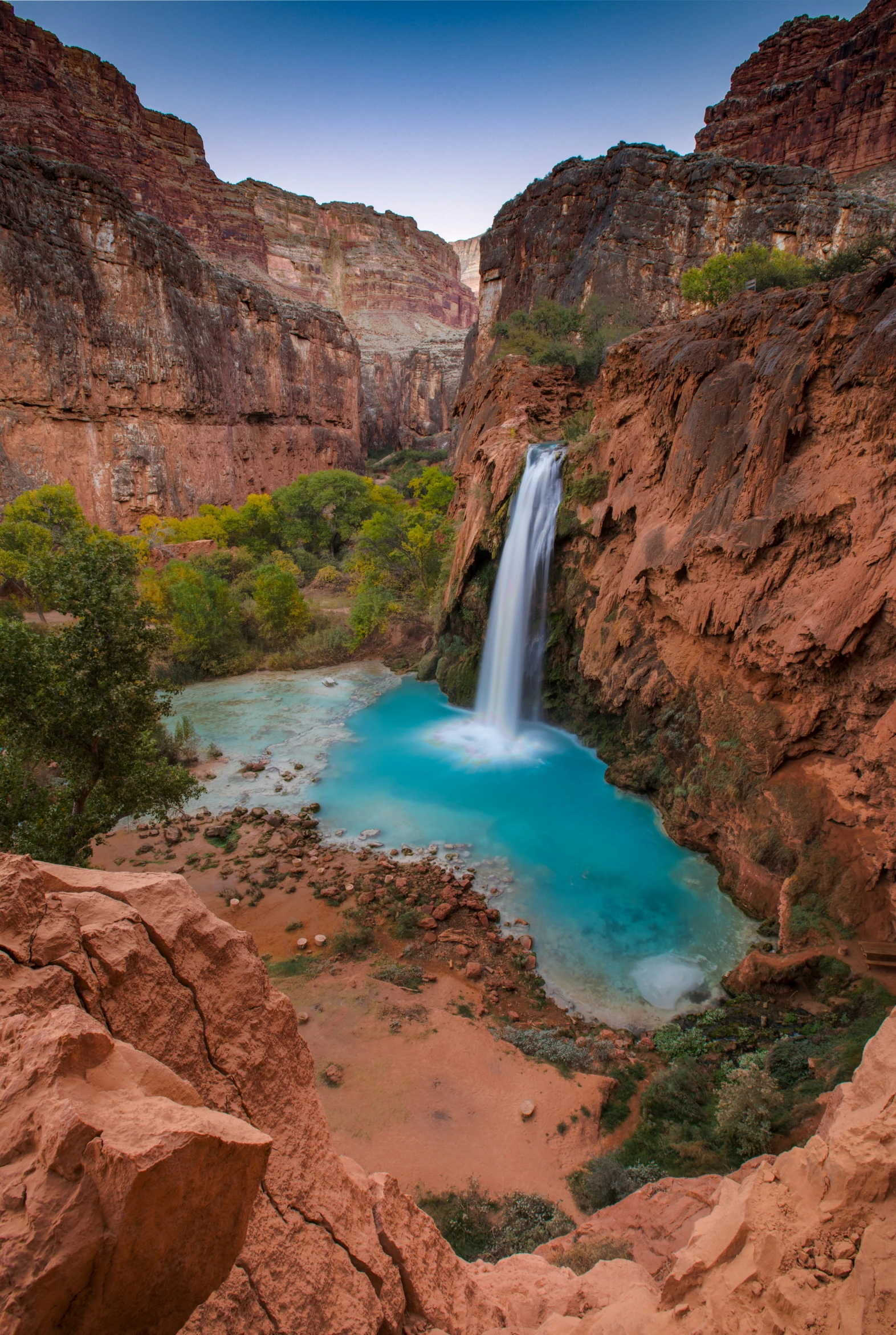 water cascading from the edge of a cliff near a waterfall