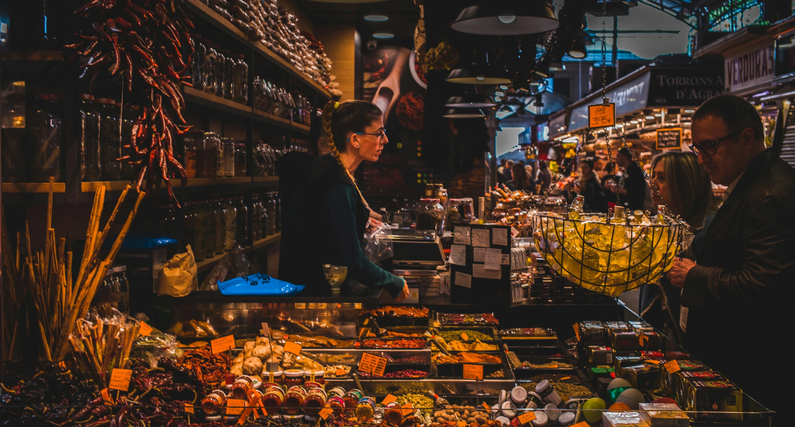 a woman stands in front of a counter filled with sweets