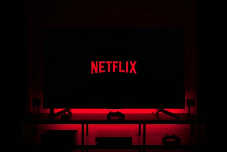 red netflix written on a dark wall and on a desk