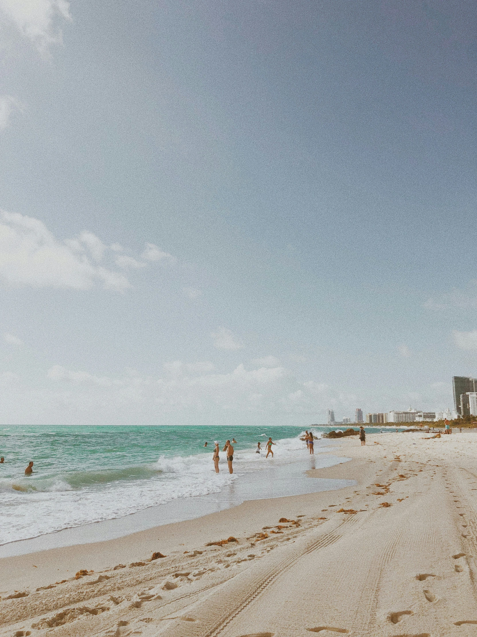 the ocean is calm and empty and people are enjoying the beach