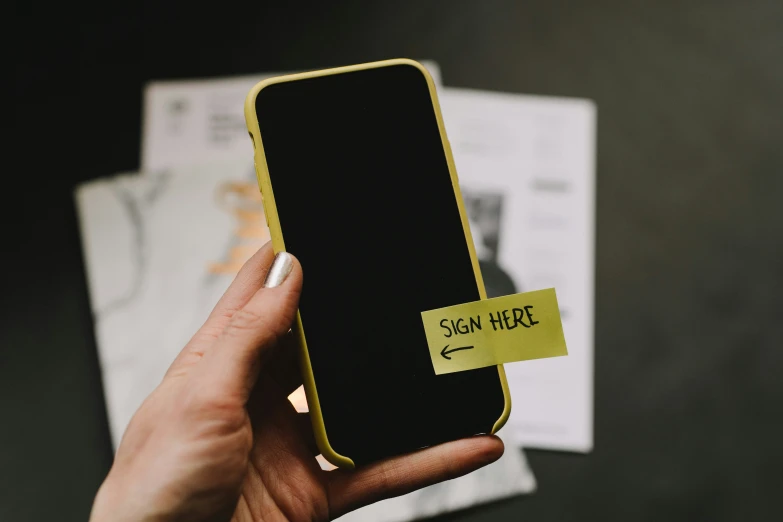 someone holding a phone with a sign on it