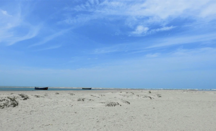 a long boat in the water on top of a beach