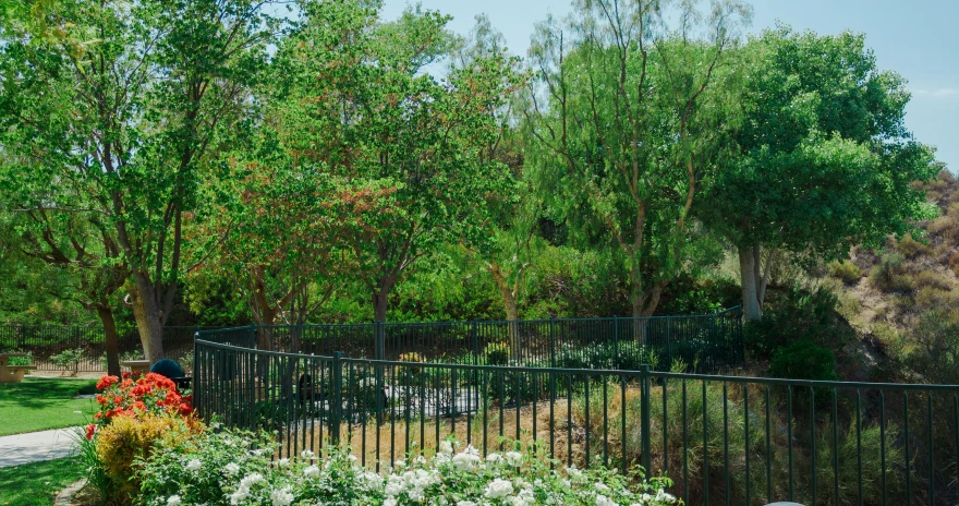 the tall planter has various flowers in it