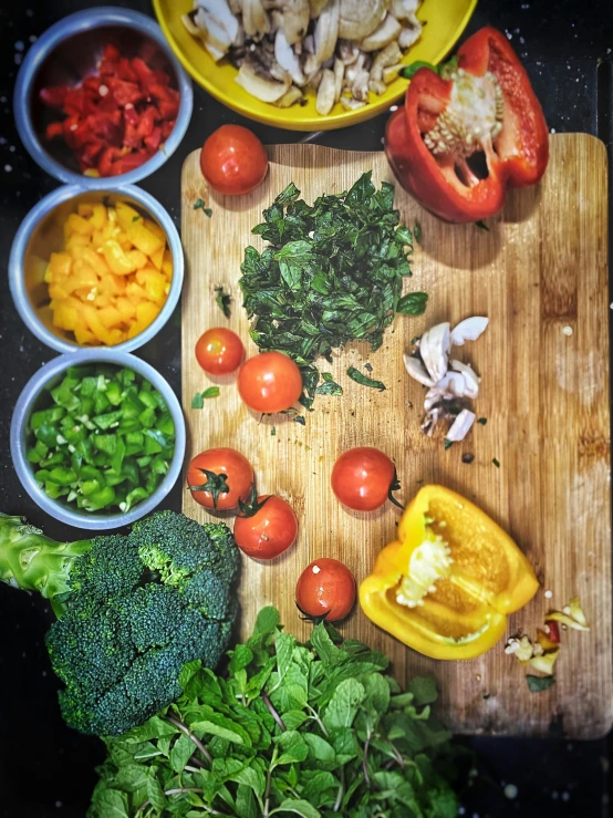 some bowls with some vegetables and a  board