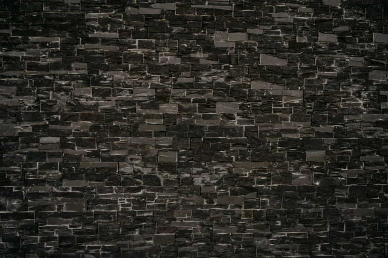 the wall is made of dark blocks of grey bricks