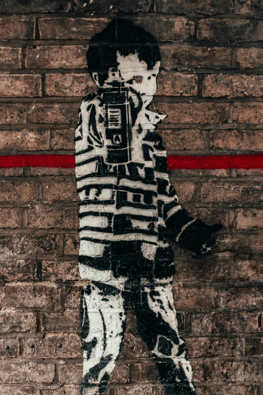 a picture of a boy with a camera standing near brick wall