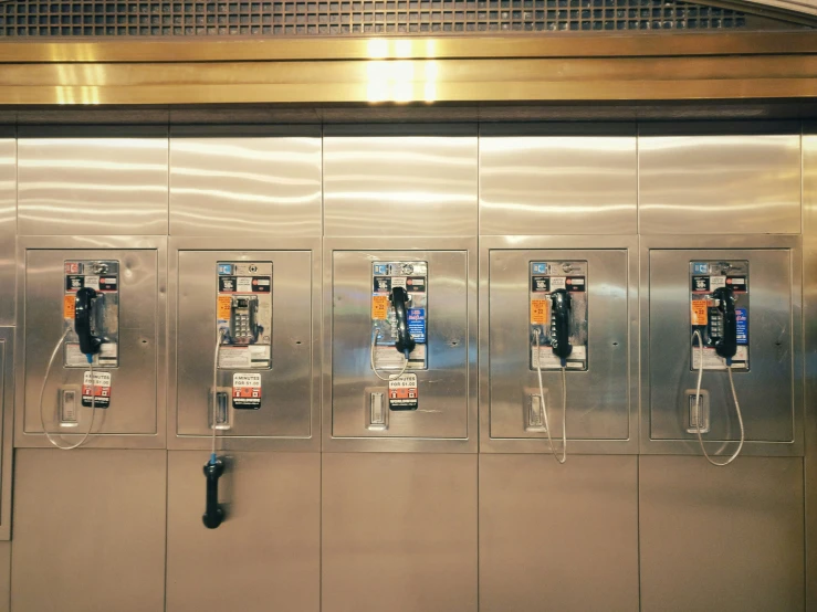 many phones mounted on the side of the wall