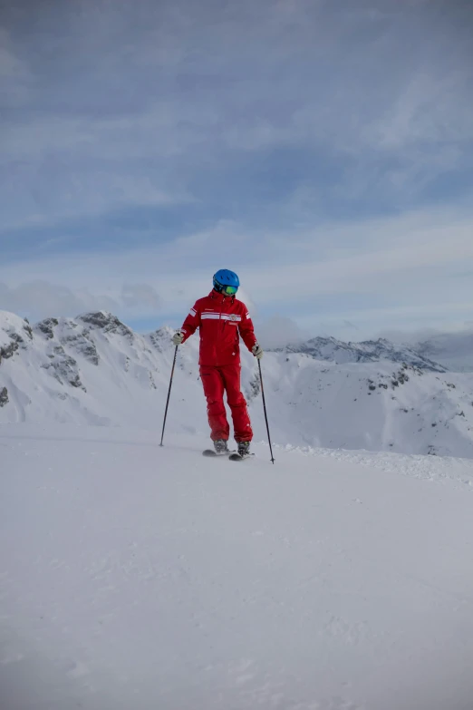 a man skiing on a snowy mountain with a blue helmet