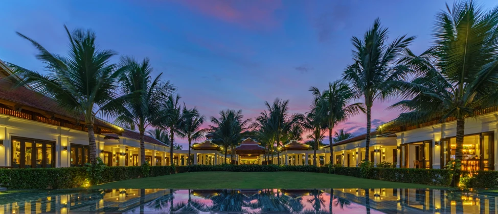 an outdoor swimming pool surrounded by palm trees