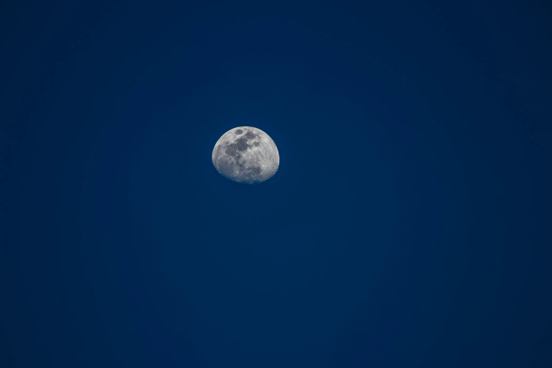 a large full moon is lit up in the dark night sky