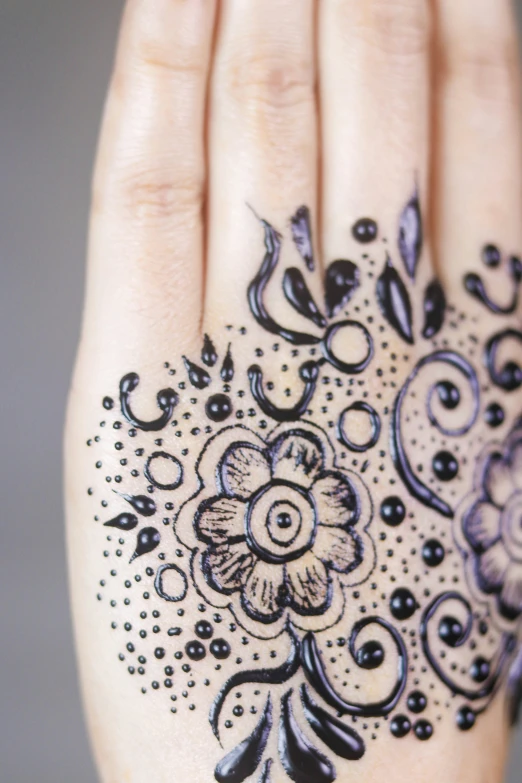 a woman's hand is adorned with a flower - design