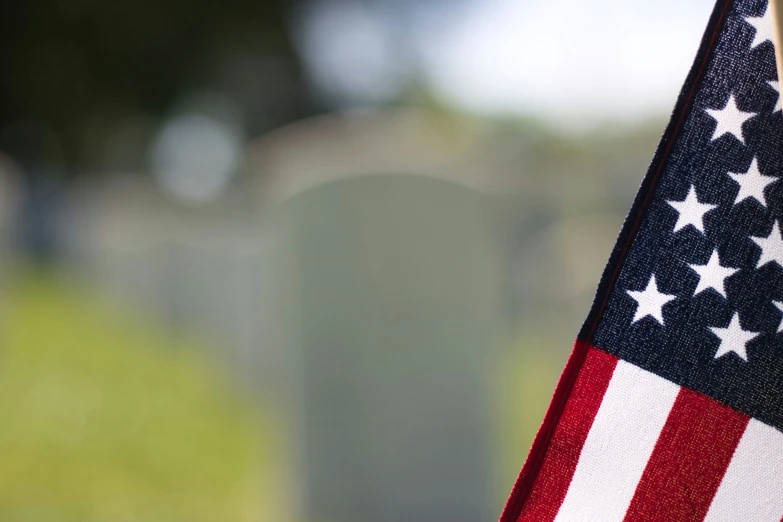 an american flag sitting in front of a grave