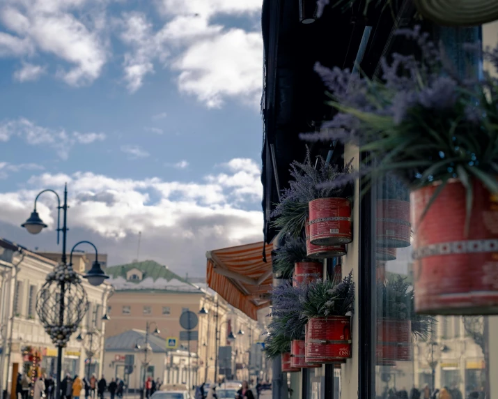 the corner of a city street with shops, a tall building, and a clock tower