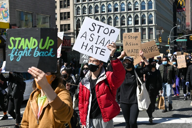 a crowd of people with protest signs on a street