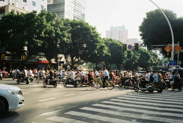 a large group of people riding motorcycles down a street