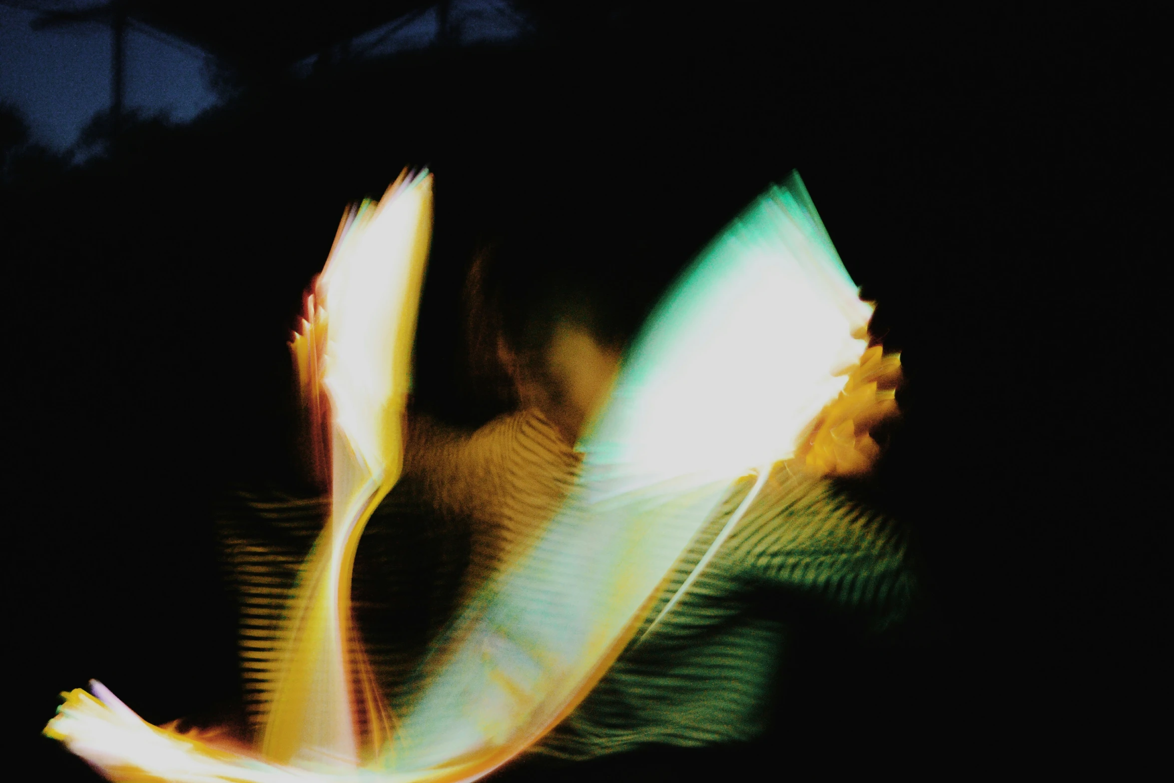 a blurry image of a woman's torso, with the light of a camera lens and the bright colors