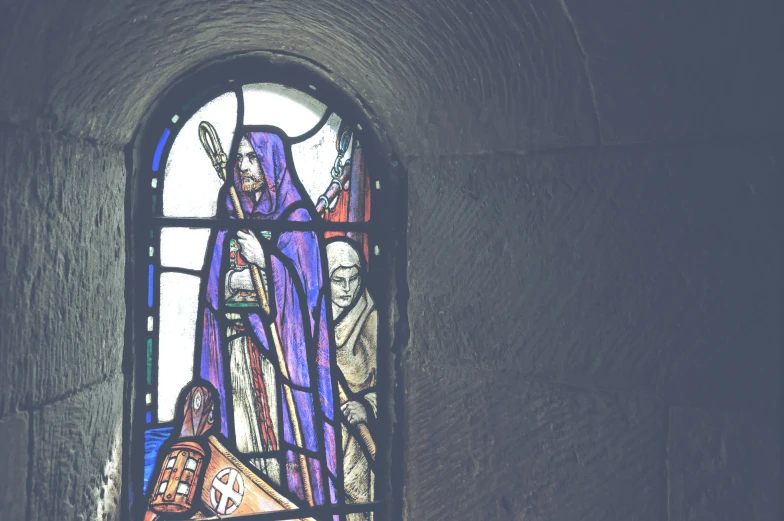 a stained glass window in the inside of a stone wall