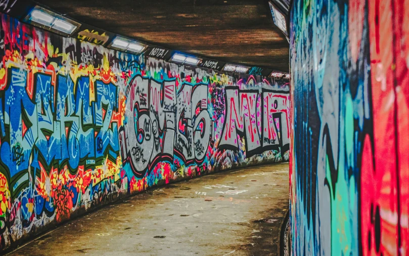 colorful graffiti painted on walls of a tunnel