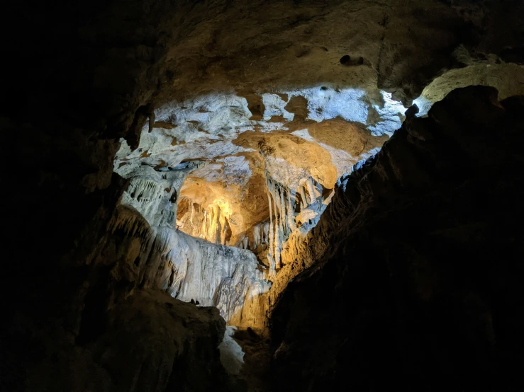 an caves entrance with stalat lights shines through