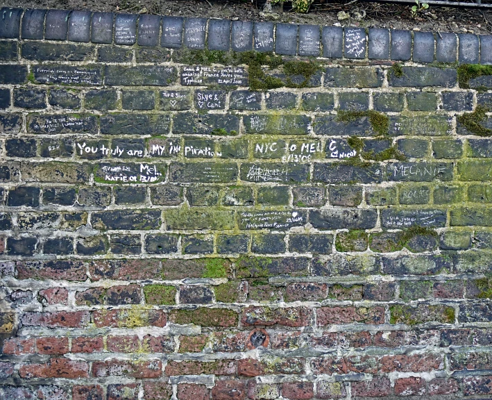 a brick wall with writing in different languages